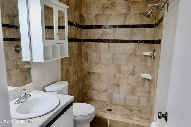 a bathroom with a sink toilet and shower