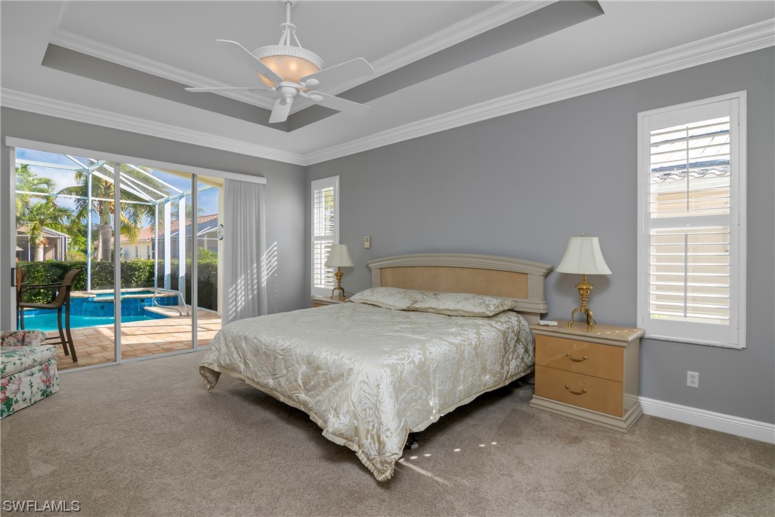 9057 Whitfield Drive Estero, FL 33928 - Photo 16 of 28 a spacious bedroom with a bed and a chandelier