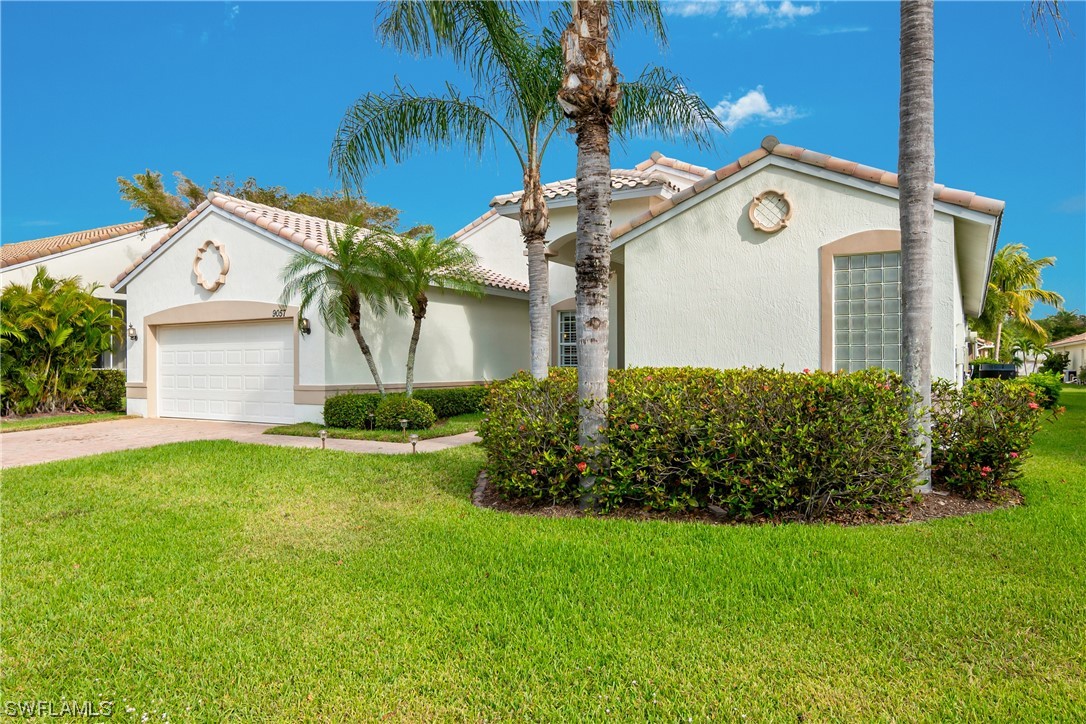 9057 Whitfield Drive Estero, FL 33928 - Photo 3 of 28 a view of a white house with a big yard and potted plants