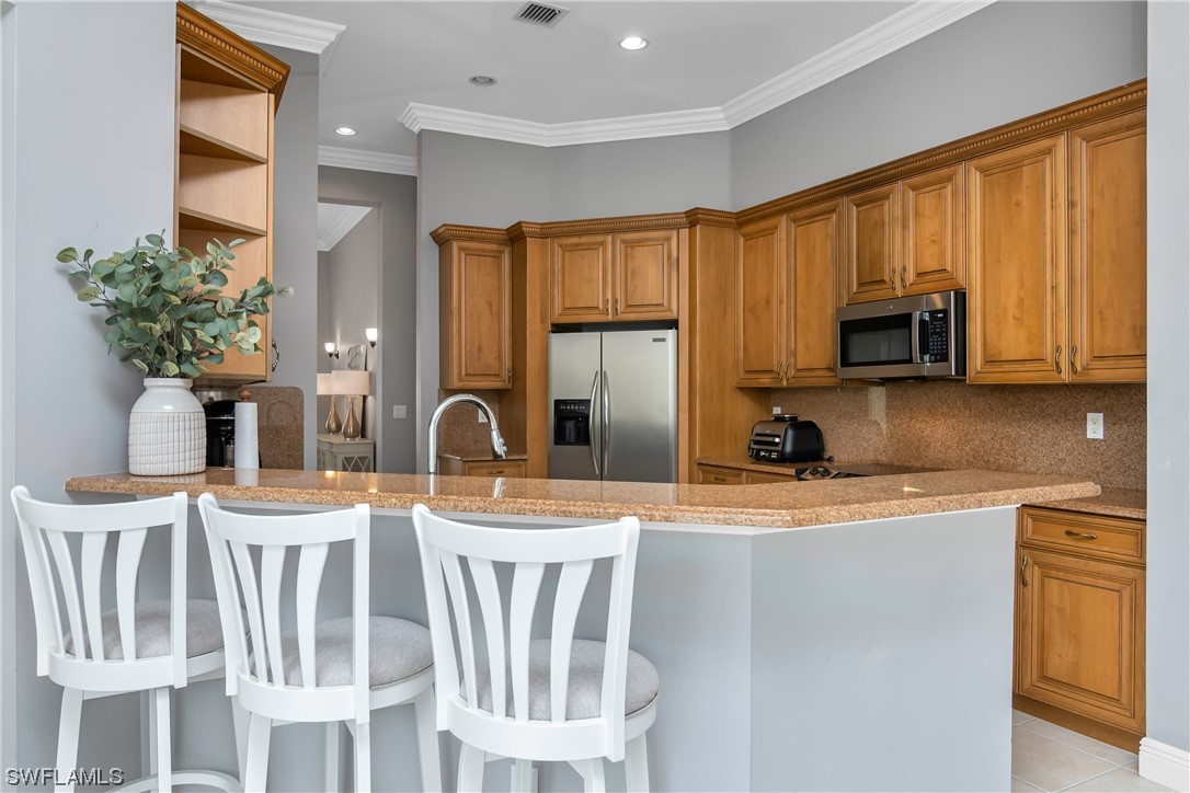 9057 Whitfield Drive Estero, FL 33928 - Photo 9 of 28 a kitchen with stainless steel appliances granite countertop a stove a sink and a microwave