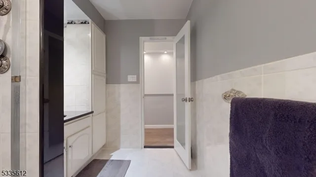a bathroom with a walk in closet and wooden floor