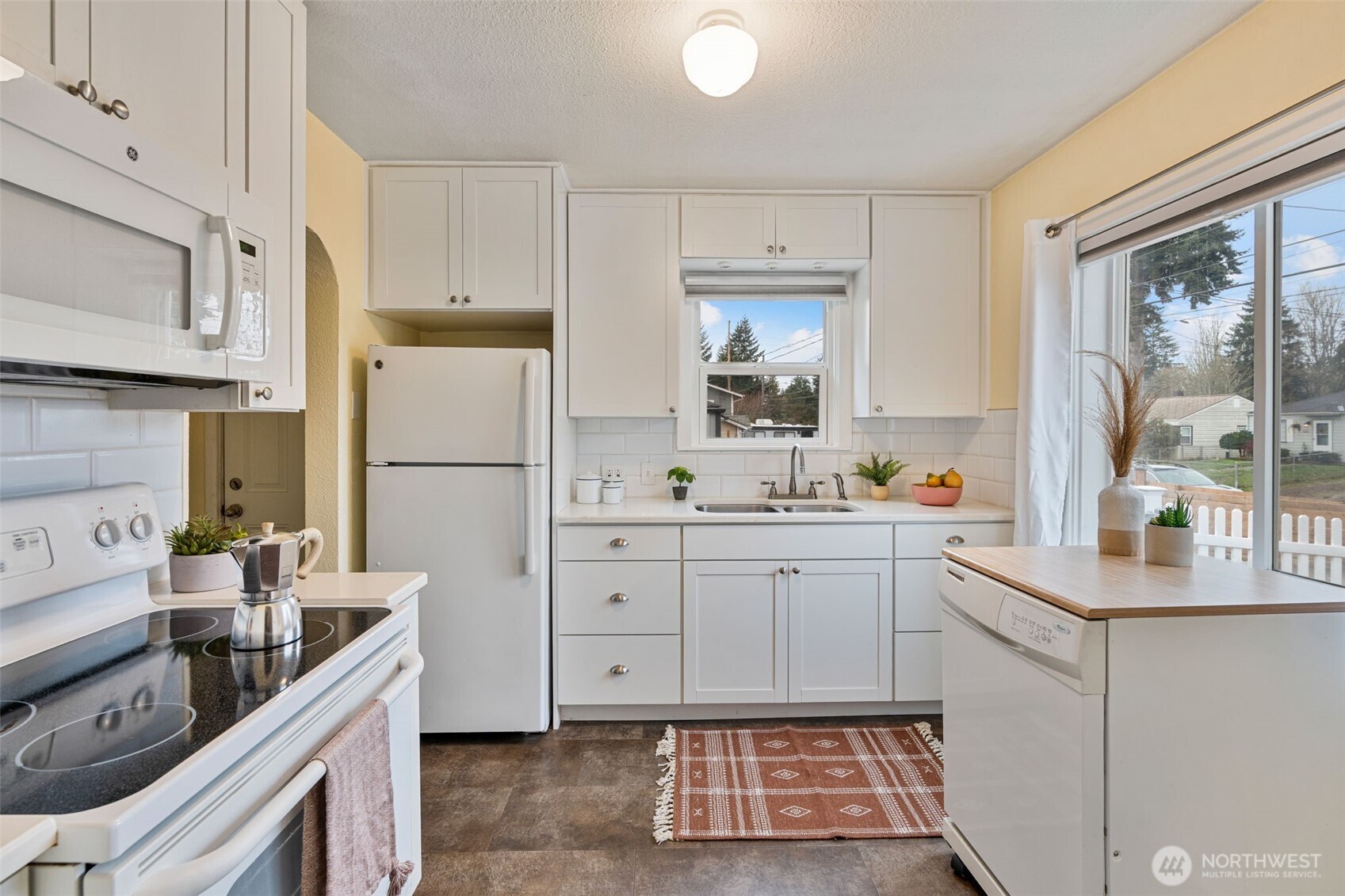 1027 South Rochester Street Tacoma, WA 98465 - Photo 10 of 29 a kitchen with white cabinets and white appliances