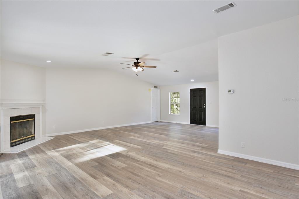 15330 Apache Pass Eustis, FL 32726 - Photo 17 of 44 a view of empty room with wooden floor and fireplace