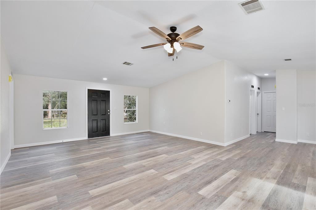 15330 Apache Pass Eustis, FL 32726 - Photo 19 of 44 a view of an empty room with a window and wooden floor
