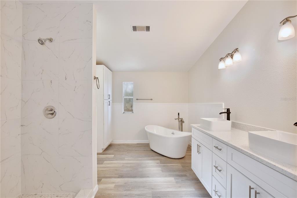 15330 Apache Pass Eustis, FL 32726 - Photo 22 of 44 a spacious bathroom with a double vanity sink and mirror
