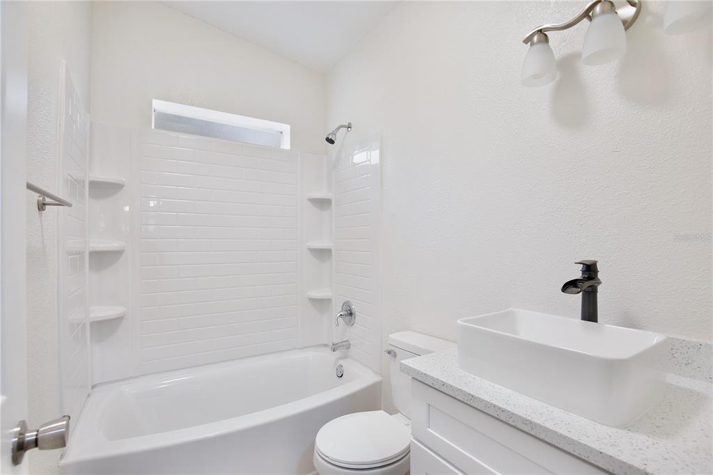 15330 Apache Pass Eustis, FL 32726 - Photo 26 of 44 a bathroom with a bathtub shower sink vanity and toilet