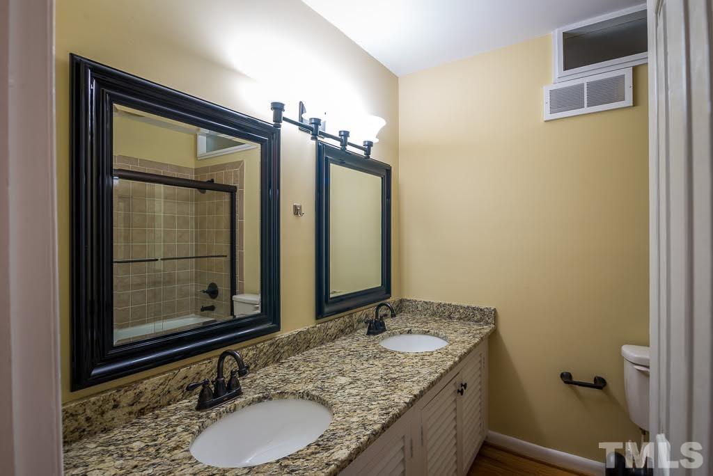 4220 Rowan Street Raleigh, NC 27609 - Photo 13 of 24 a bathroom with a granite countertop sink and a mirror