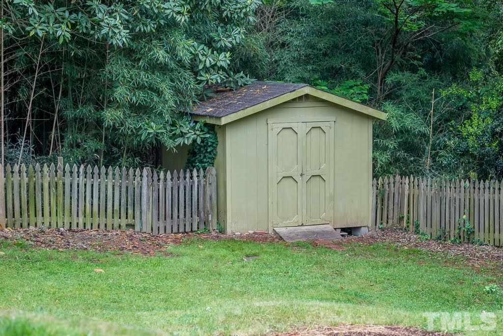 4220 Rowan Street Raleigh, NC 27609 - Photo 23 of 24 a small barn with a small yard and wooden fence