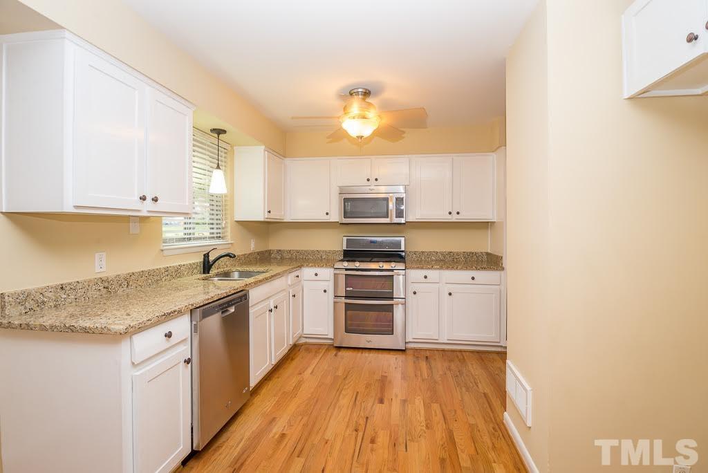 4220 Rowan Street Raleigh, NC 27609 - Photo 5 of 24 a kitchen with a sink stove and cabinets