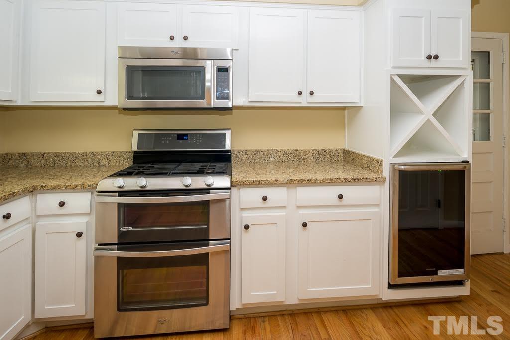 4220 Rowan Street Raleigh, NC 27609 - Photo 6 of 24 a kitchen with granite countertop white cabinets and stainless steel appliances