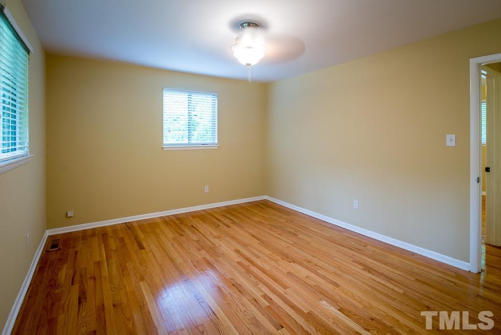 4220 Rowan Street Raleigh, NC 27609 - Photo 9 of 24 a view of empty room with wooden floor and fan