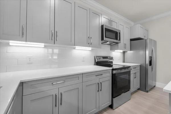 a kitchen with cabinets stainless steel appliances and sink