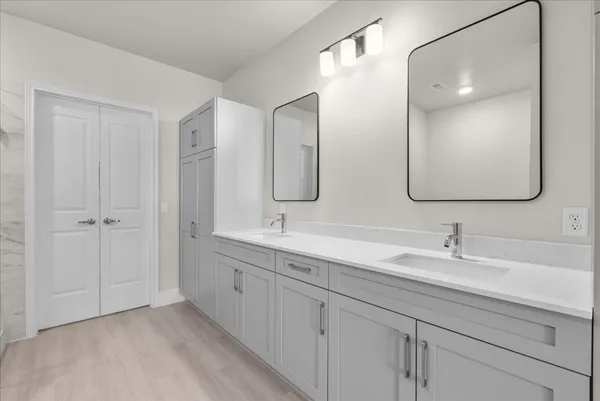 a bathroom with double vanity sinks and a mirror