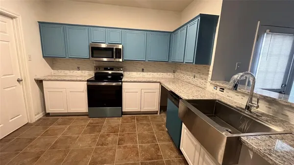 a kitchen with a sink stove and microwave