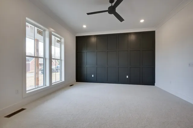 an empty room with a window and a ceiling fan