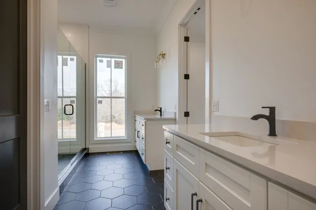 a bathroom with a double vanity sink and mirror