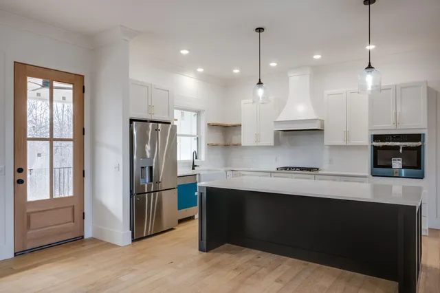 a kitchen with stainless steel appliances granite countertop a refrigerator a sink and a stove