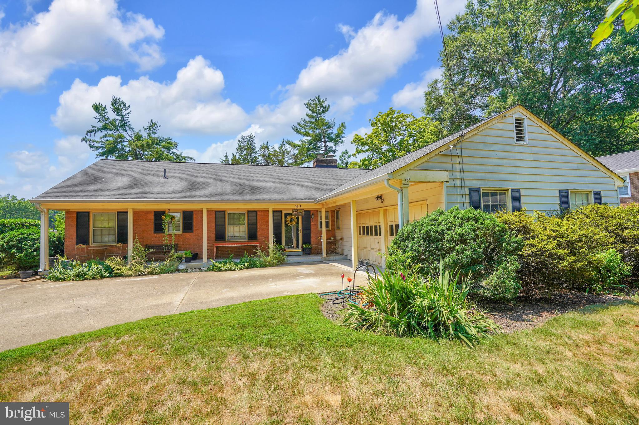 a front view of a house with a yard and potted plants