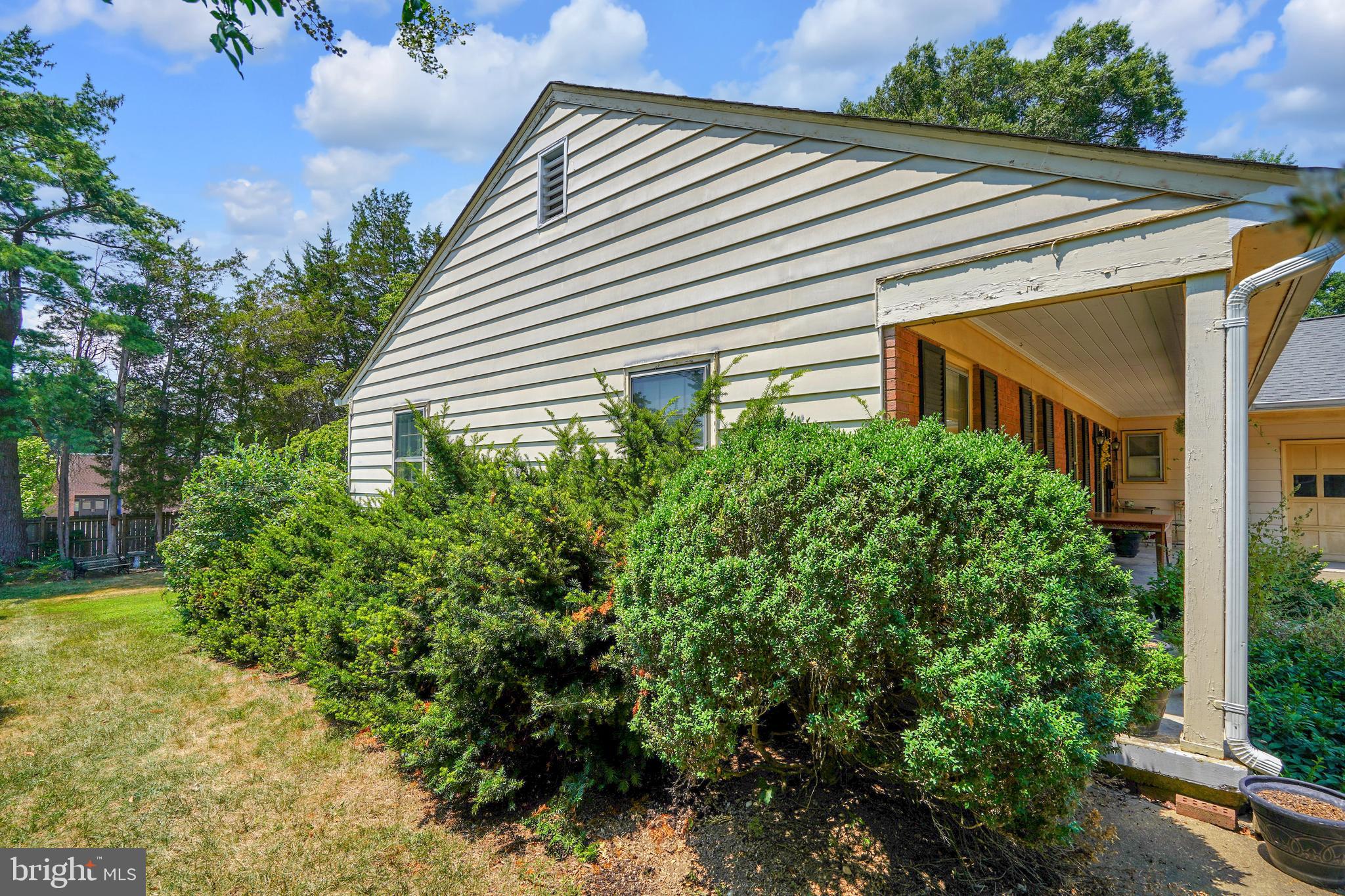 7614 Range Road Alexandria, VA 22306 - Photo 30 of 37 a yellow house with flower garden and wooden fence