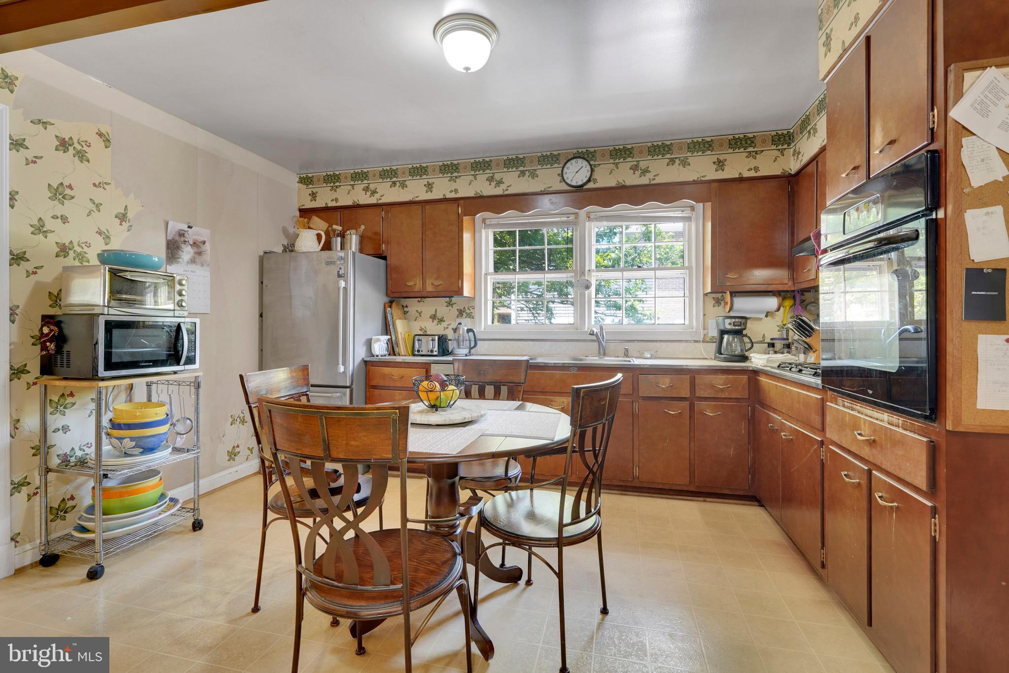 7614 Range Road Alexandria, VA 22306 - Photo 9 of 37 a kitchen with stainless steel appliances granite countertop a table and chairs in it