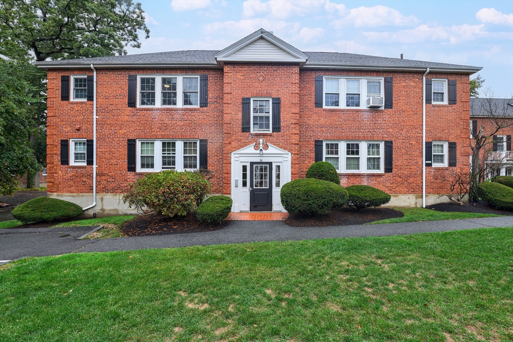 a front view of a house with garden and yard