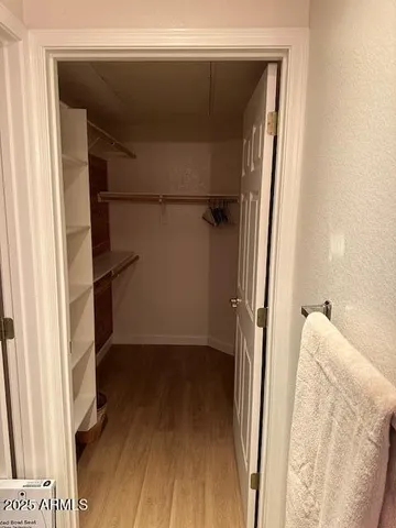 a view of walk in closet with clothes and shoes