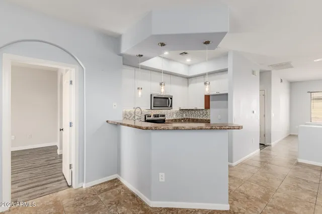 a kitchen with stainless steel appliances granite countertop a sink and a refrigerator