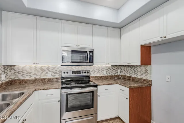 a kitchen with stainless steel appliances granite countertop a stove microwave and sink