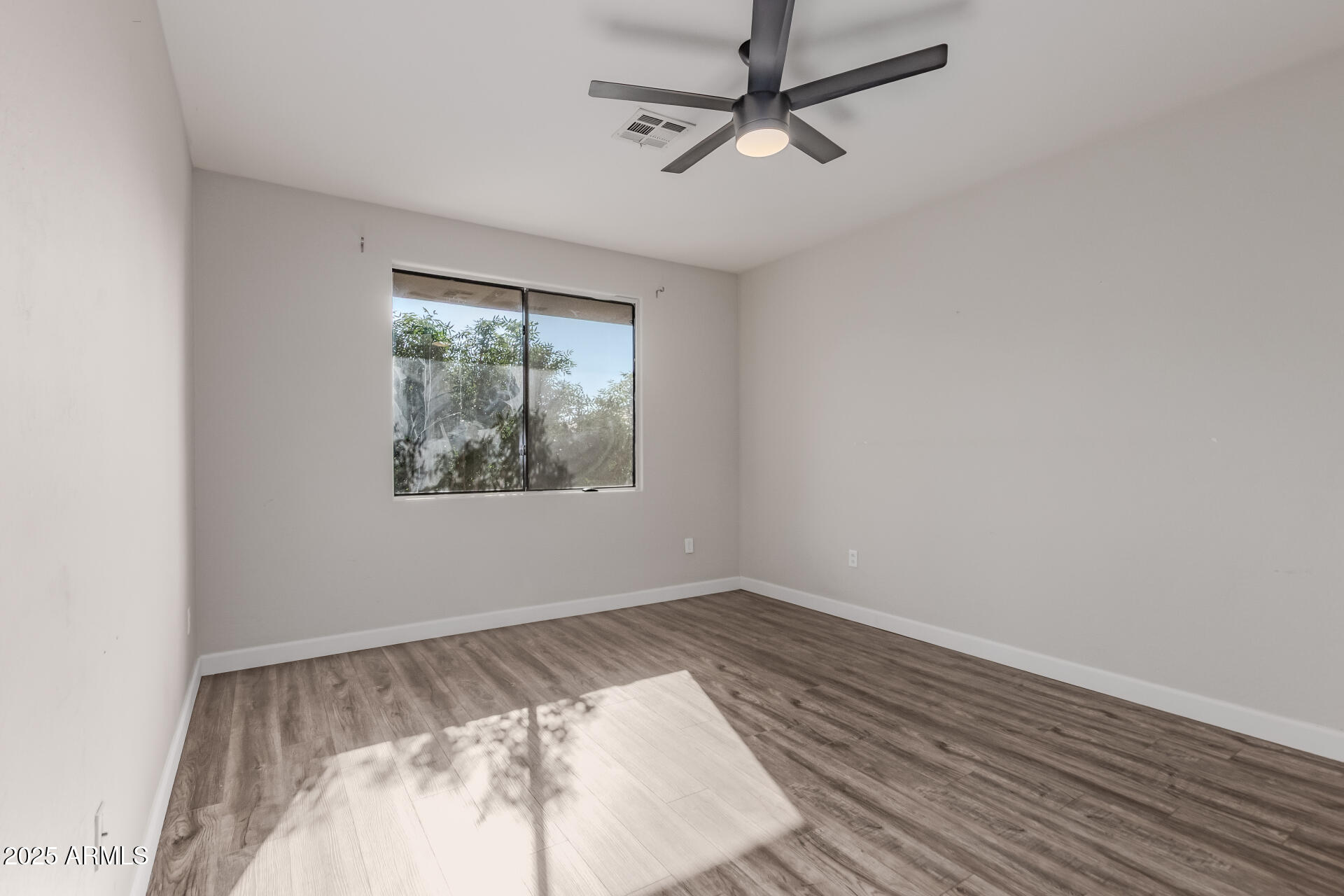705 West Queen Creek Road, Unit 2146 Chandler, AZ 85248 - Photo 16 of 44 an empty room with wooden floor ceiling fan and windows