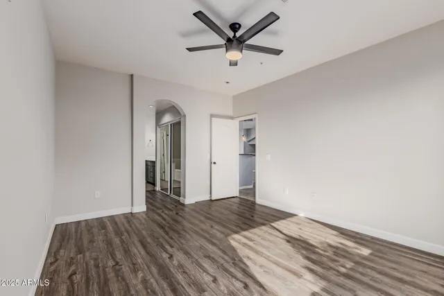 a view of a livingroom with wooden floor and a ceiling fan