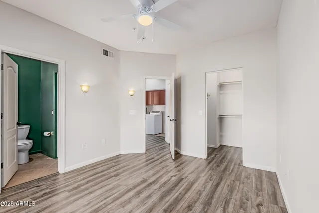 a view of a room with wooden floor and a bathroom