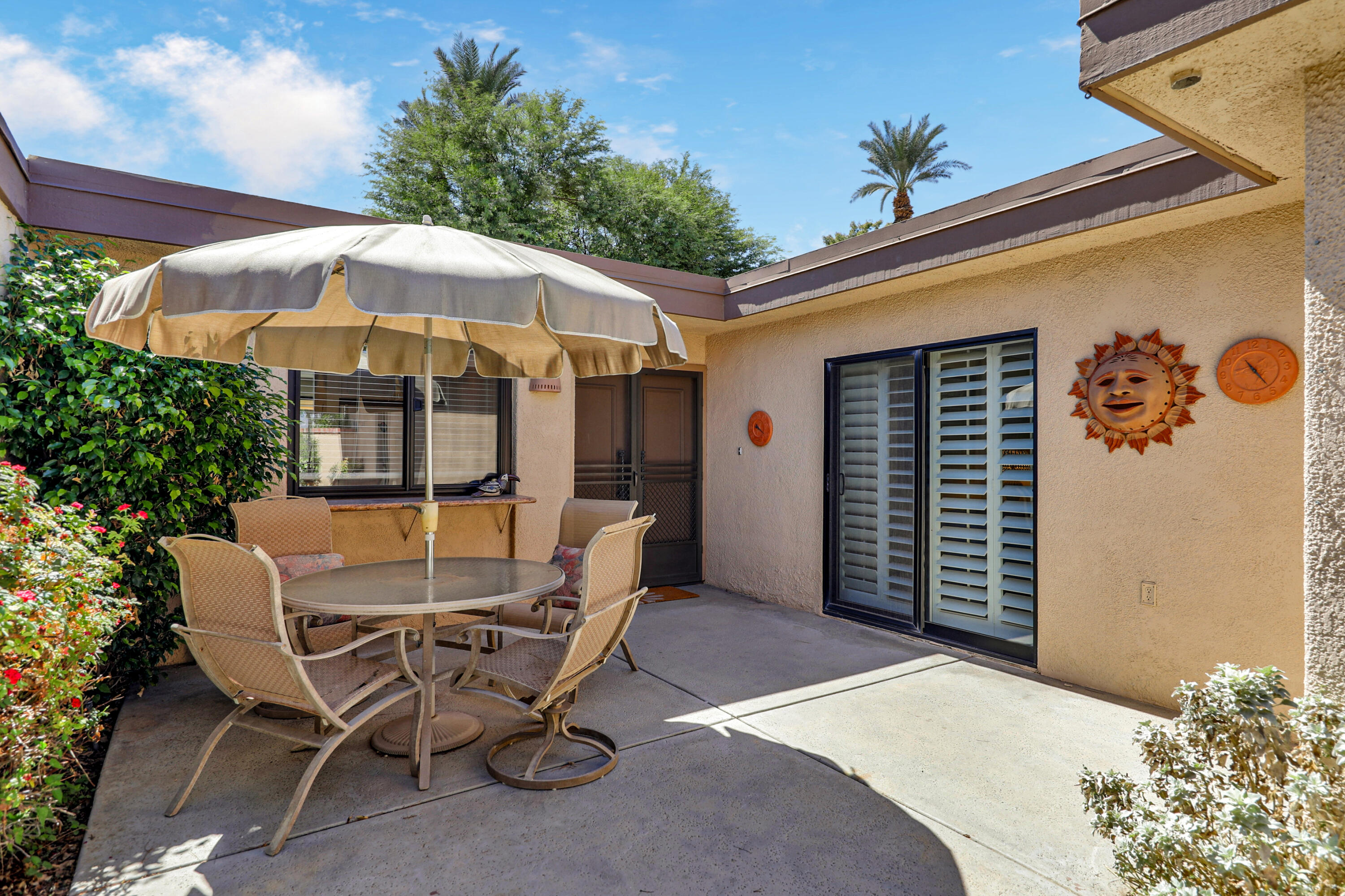 27 Seville Drive Rancho Mirage, CA 92270 - Photo 21 of 50 a patio with a table and chairs under an umbrella