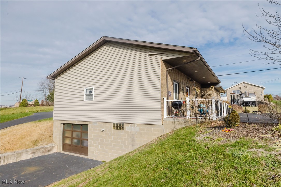 857 Archer Hill Road Colliers, WV 26035 - Photo 6 of 37 View of property exterior with a patio area, a lawn, asphalt driveway, and a garage