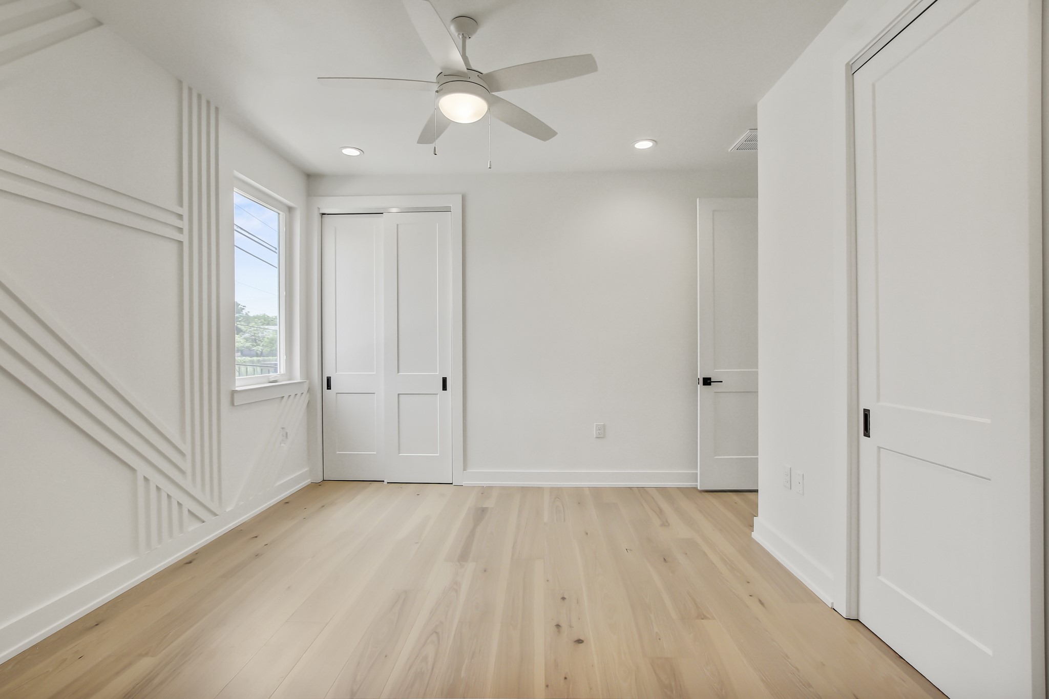 4127 East 12th Street, Unit 8 Austin, TX 78721 - Photo 18 of 32 Unfurnished bedroom with light wood finished floors, recessed lighting, baseboards, and ceiling fan