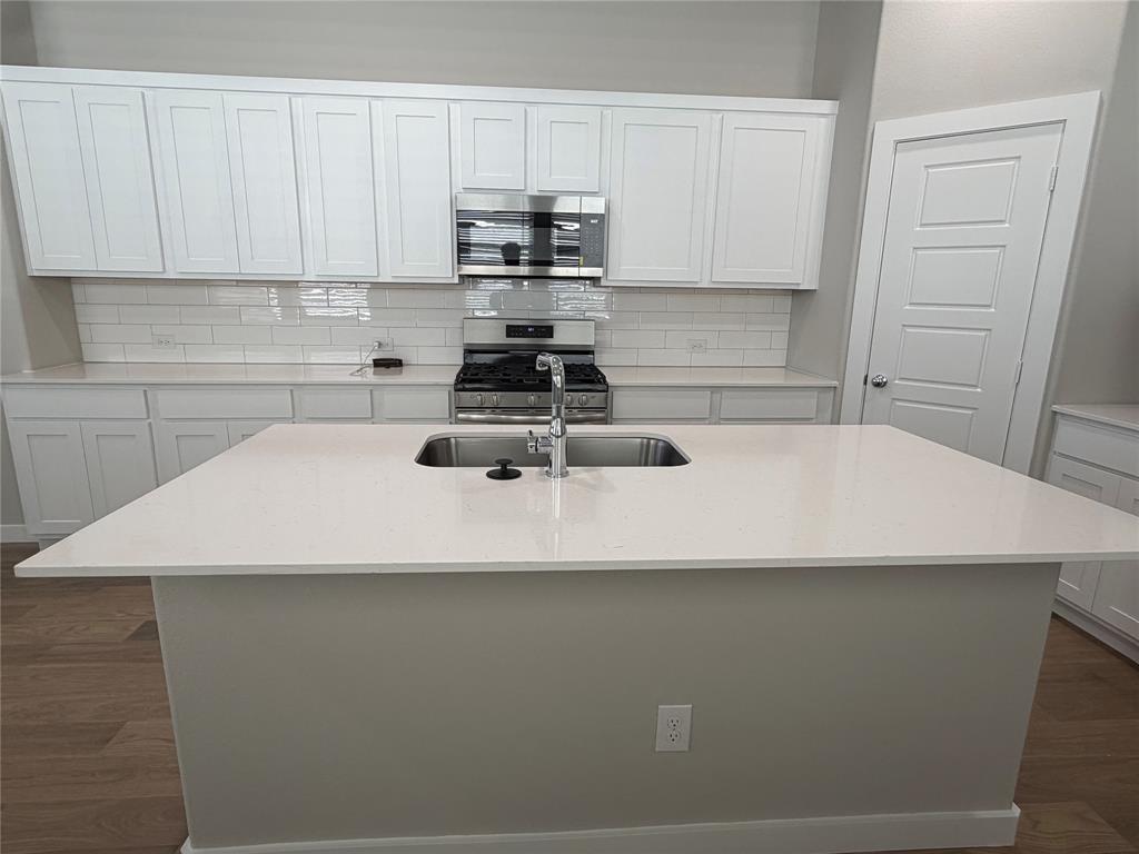 517 River Rdg Drive McKinney, TX 75071 - Photo 2 of 14 a kitchen with a sink a stove and white cabinets