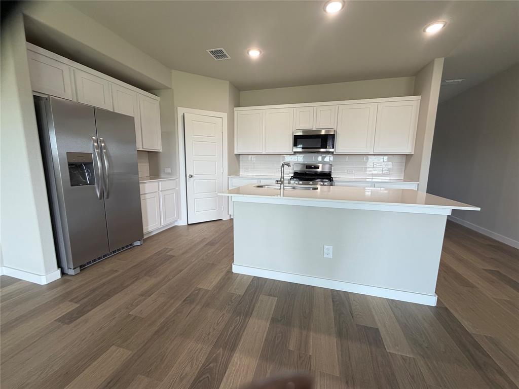 517 River Rdg Drive McKinney, TX 75071 - Photo 3 of 14 a kitchen with stainless steel appliances a refrigerator a sink a stove and cabinets