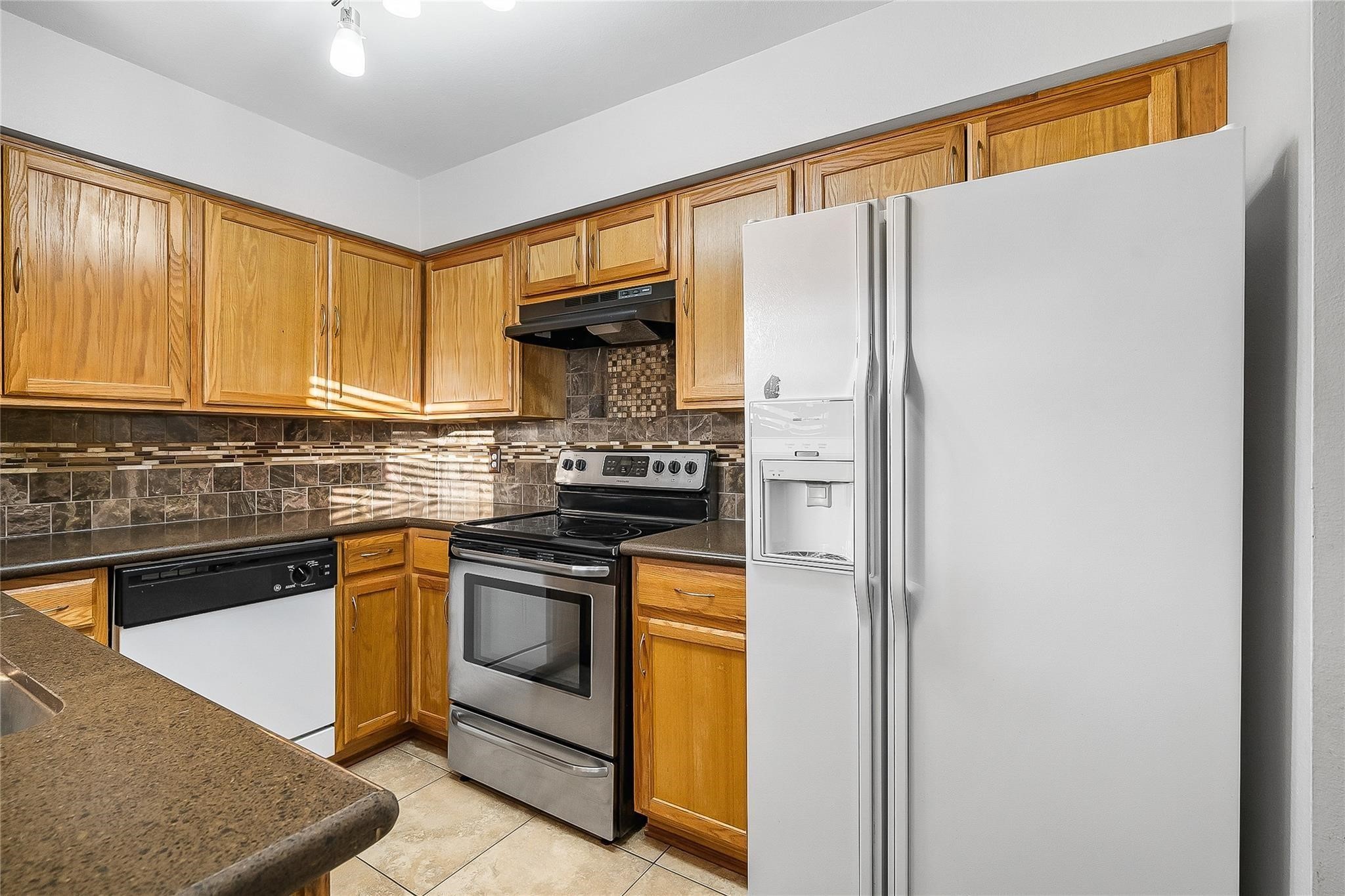 3100 Walnut Bend Lane, Unit 116 Houston, TX 77042 - Photo 6 of 15 a kitchen with stainless steel appliances granite countertop a refrigerator and a stove top oven
