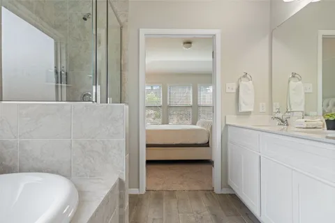 a en suite bathroom with a tub sink and mirror