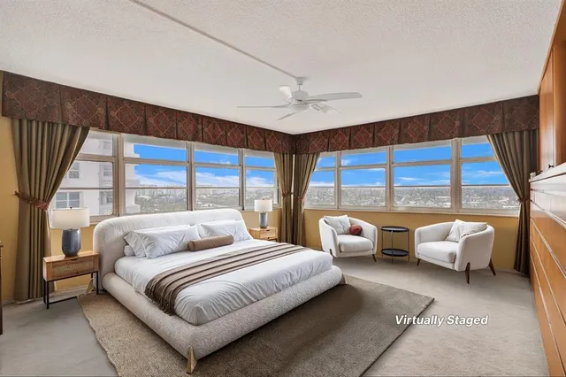 a bedroom with furniture and large windows