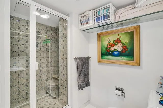 a bathroom with a painting on the wall and shower