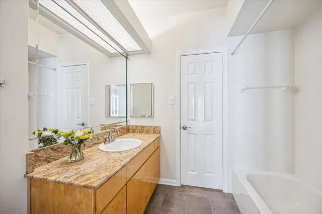 a bathroom with a granite countertop sink mirror and toilet