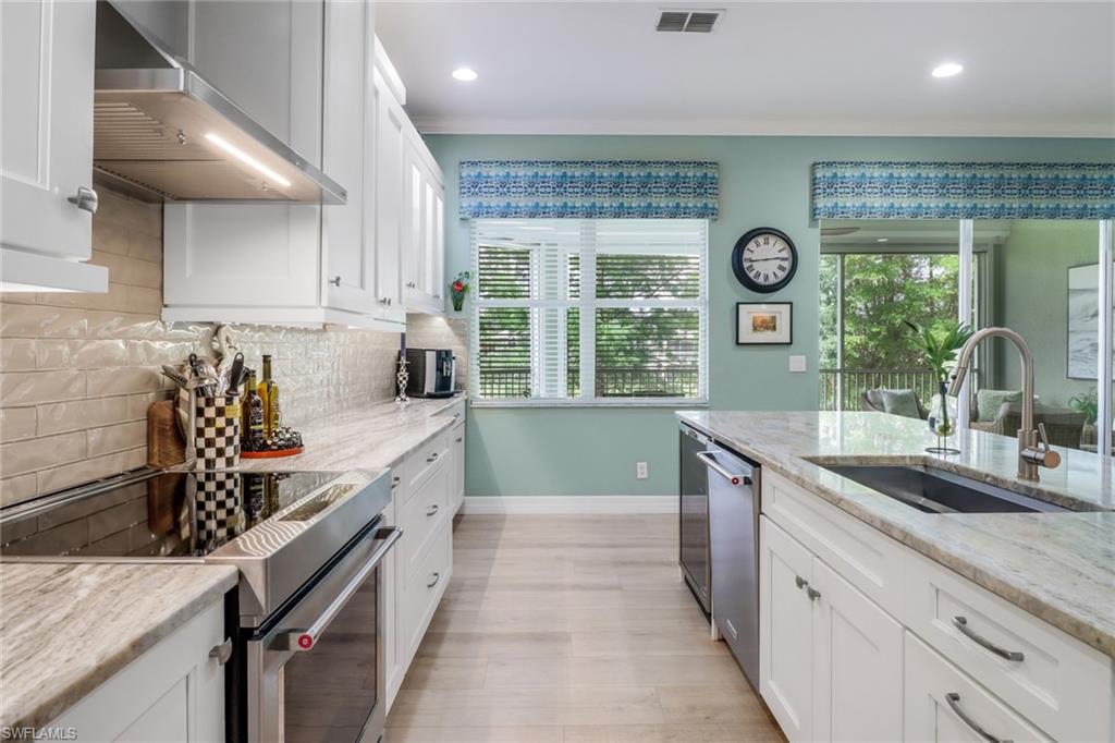 3530 Lansing Loop, Unit 204 Estero, FL 33928 - Photo 16 of 48 a kitchen with stainless steel appliances granite countertop a stove and a sink