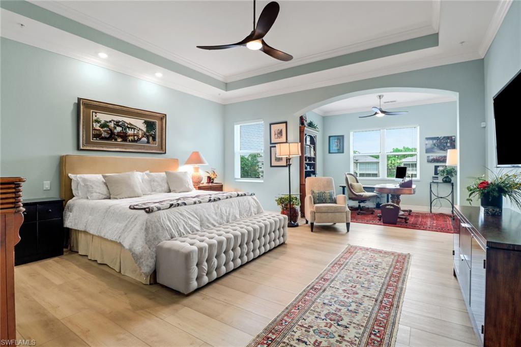 3530 Lansing Loop, Unit 204 Estero, FL 33928 - Photo 17 of 48 a spacious bedroom with a bed a couch and a flat screen tv