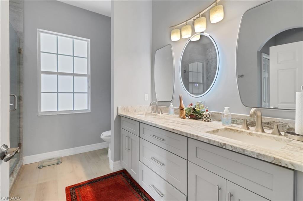 3530 Lansing Loop, Unit 204 Estero, FL 33928 - Photo 26 of 48 a bathroom with a granite countertop double vanity sink and a mirror