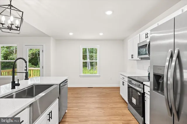 a kitchen with granite countertop a sink stainless steel appliances and cabinets