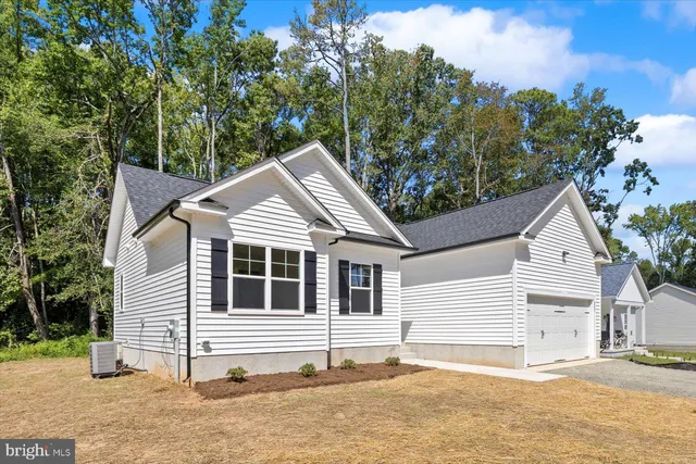 a white house that has a tree in front of it