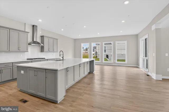 a kitchen with stainless steel appliances sink cabinets and wooden floor