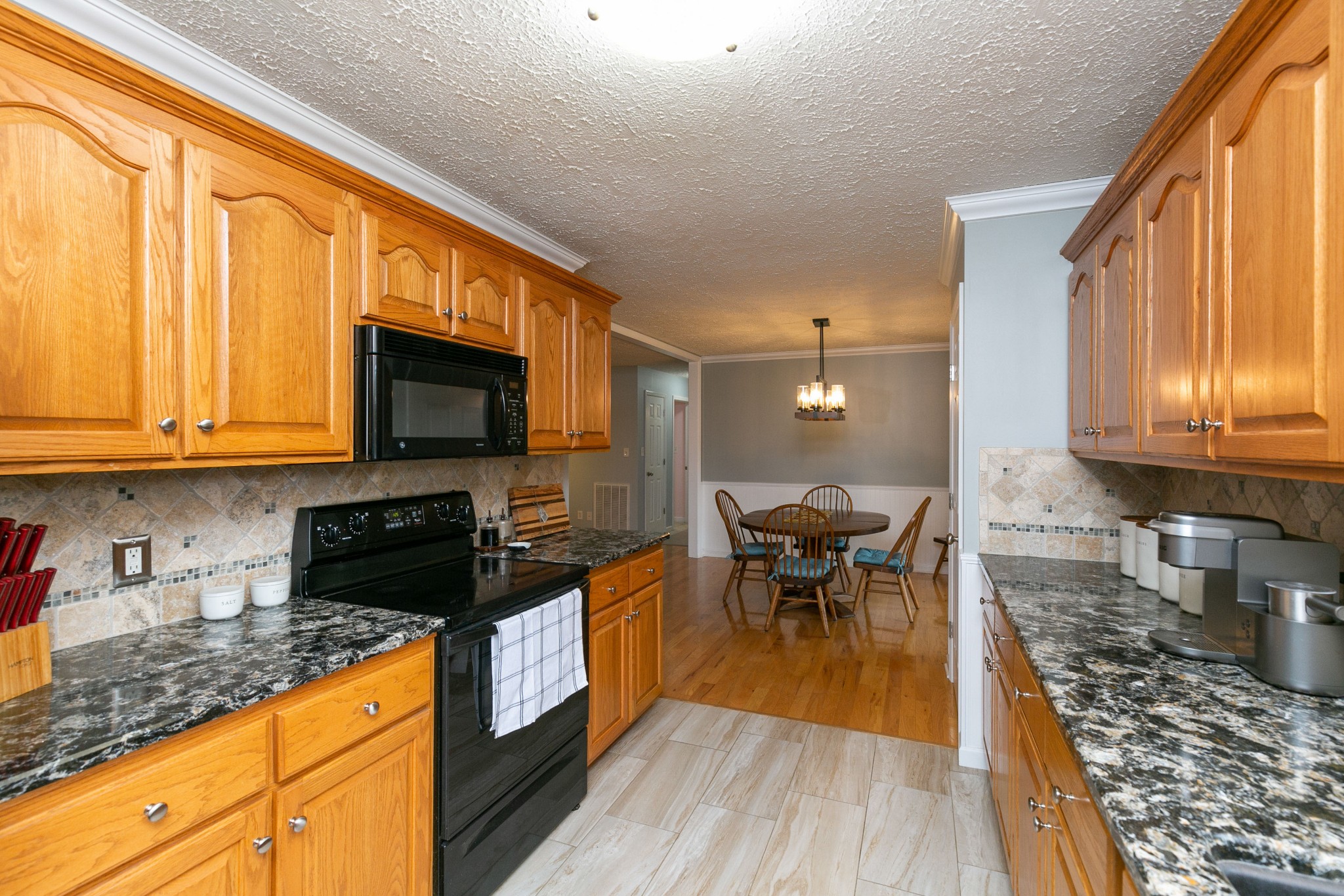 19 B Vantrease Road Brush Creek, TN 38547 - Photo 13 of 41 a kitchen with stainless steel appliances granite countertop a stove top oven a sink dishwasher a dining table and chairs with wooden floor