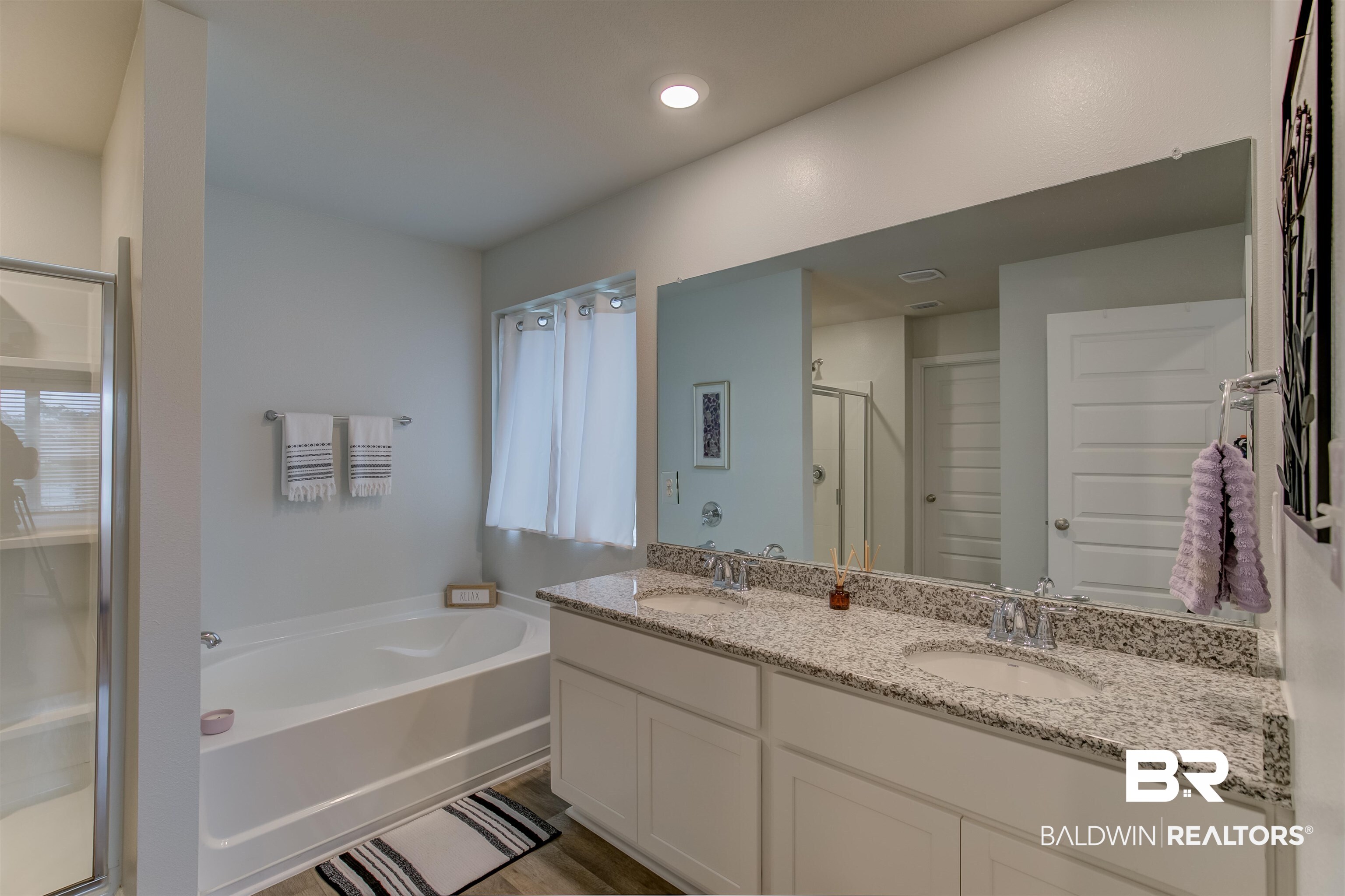 8033 Irwin Loop Daphne, AL 36526 - Photo 24 of 38 Bright bathroom featuring a dual vanity with a patterned countertop, undermount sinks, and chrome fixtures