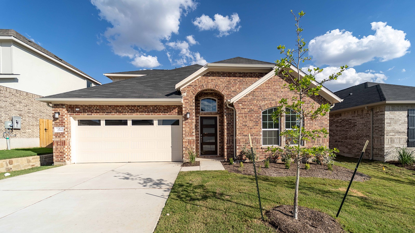 294 Rubber Tree Way Buda, TX 78610 - Photo 1 of 19 Ranch-style house with an attached garage, driveway, brick siding, and a front yard